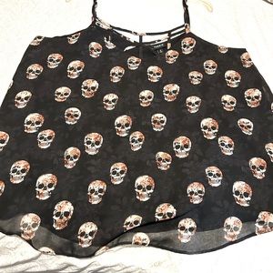 Skull top size 0. It’s black and cream colored skulls. Fits bigger then a zero.